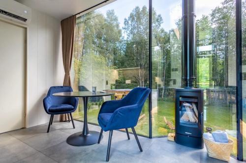 a room with a table and chairs and a fireplace at Forest Reflection Minivilla in Partsi