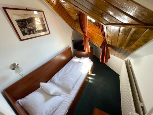 a small bedroom with a bed in the attic at Hotel Főnix in Pécs