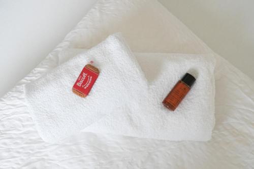 two towels on a bed with a bottle of soap at KasselRooms Design Studio in Kassel
