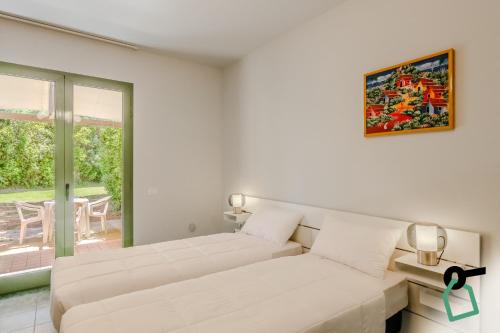 a white living room with a couch and a window at Hotiday Marina di Cecina in La Cinquantina