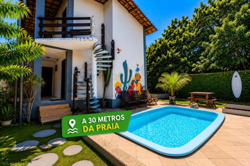 a sign in front of a house with a swimming pool at Pousada Toa Toa Em Pipa in Pipa