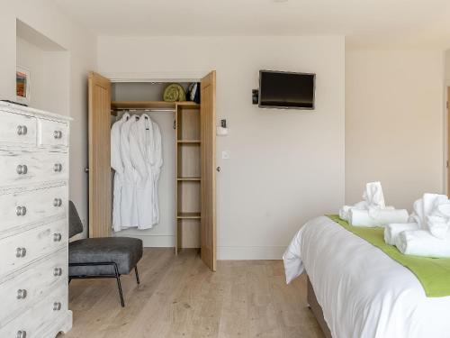 a bedroom with a bed and a closet with a dresser at The Stables in Stanhope