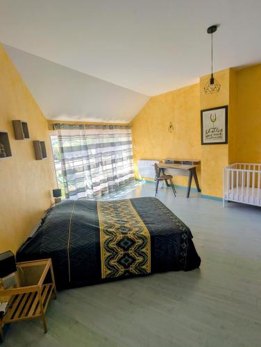 a bedroom with a bed and a table in a room at Gite Entre Pierre et Come in Chablis