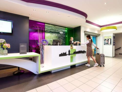 Eine Frau steht an einem Tresen in einem Geschäft in der Unterkunft ibis Styles Luzern in Luzern