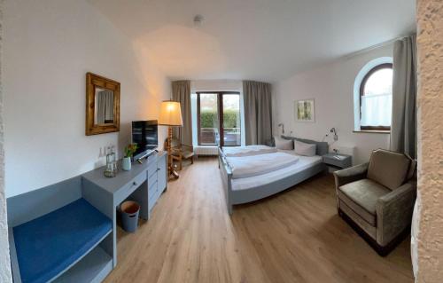 a bedroom with a bed and a couch and a chair at Hotel Bihler in Bad Aibling