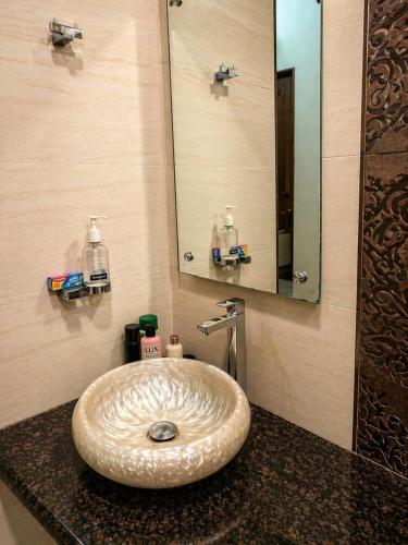 a bathroom with a sink with a large mirror at Urbana Luxury AC Duplex Bungalow with Pergola Terrace in Nagpur