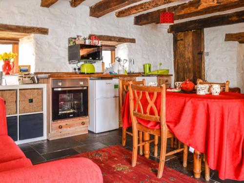 a kitchen with a table with a red table cloth at Ty Fferm Hen - Uk36420 in Talybont