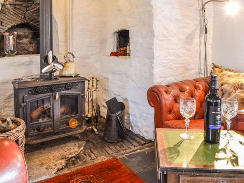 a living room with a couch and a stove at Ty Fferm Hen - Uk36420 in Talybont