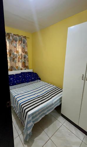 a small bedroom with a bed in a yellow room at Stay at Amazing Grace, whole unit- VCDU subdivision , Mabini Plains in Mabini