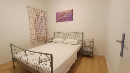 a bedroom with a white bed with two pillows at Wind Rose Apartments Sumartin in Sumartin