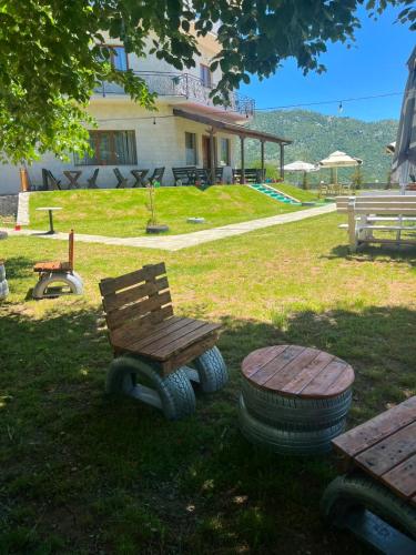 a wooden bench and a stool in a yard at Razem Lendina e Qete in Razëm