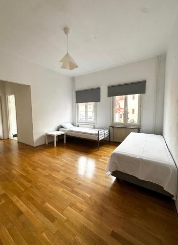 a large white room with two beds and wooden floors at Lägenhet Centrum Karlshamn in Karlshamn