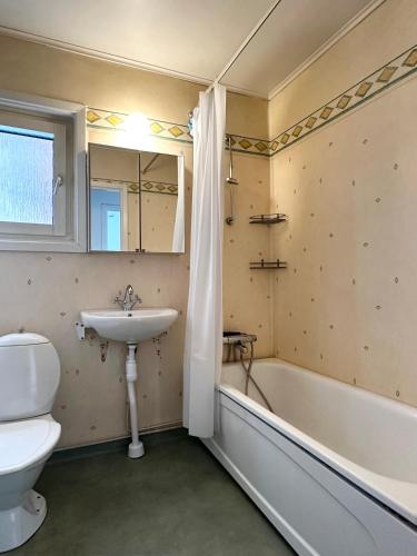 a bathroom with a sink and a toilet and a tub at Lägenhet Centrum Karlshamn in Karlshamn
