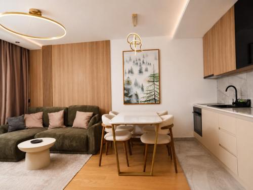 a living room with a couch and a table at Hedonist Wellness & Spa in Zlatibor