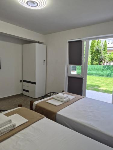 a bedroom with two beds and a large window at Silitur Keramoti in Keramoti