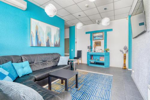 a living room with a couch and a blue wall at Jūras Vilks in Ventspils