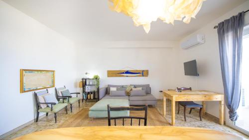 a living room with a couch and a table and chairs at Solemar Sicilia - Casa Bella in Bagheria