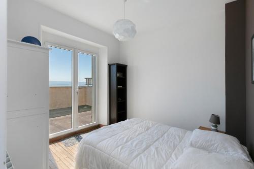 a bedroom with a bed and a large window at Villa Timao Plage in Batz-sur-Mer