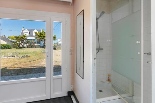 a bathroom with a shower and a glass door at Villa Timao Plage in Batz-sur-Mer