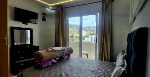 a bedroom with a bed with a large window at Casa ahlam in Chefchaouen