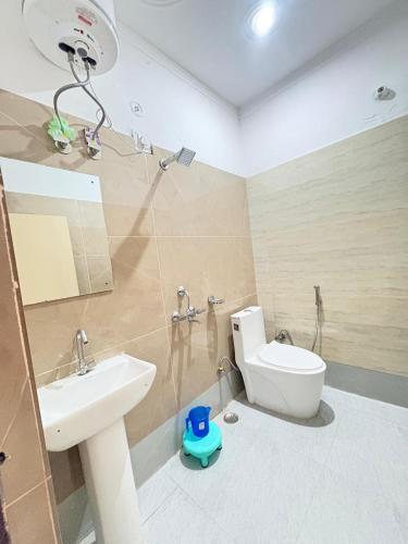a bathroom with a sink and a toilet and a shower at Hotel Ganpati place in Uttarkāshi