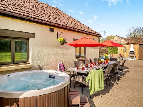 a patio with a table and a hot tub at The Big Old Dairy in Weston-super-Mare