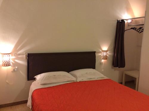 a bedroom with a red bed with two white pillows at Casa Caracciolo B&B in Grottaglie