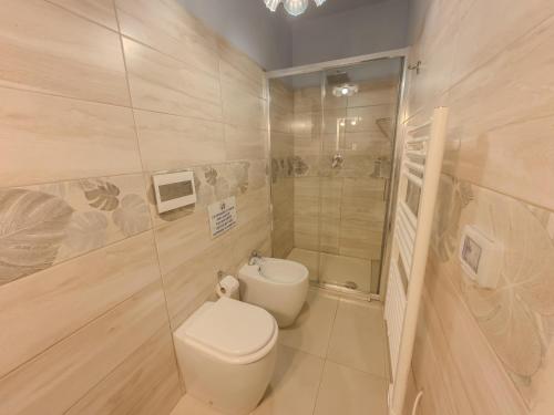 a white bathroom with a toilet and a shower at Villa Castiglione 1863 - The real Sicilian holiday in Ragusa
