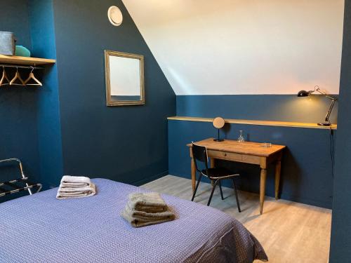 a bedroom with blue walls and a desk and a bed at Les Griottes Gite de charme in Verdigny