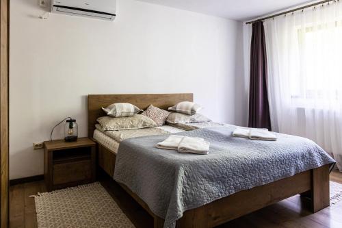 a bedroom with a bed with two towels on it at CASA CODRILOR - Greencodru liniste si relaxare in Codru