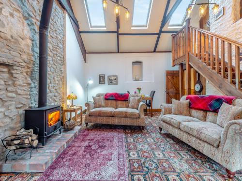 a living room with two couches and a fireplace at Yr Hen Efail in Abergorlech