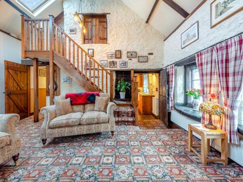 a living room with a couch and a staircase at Yr Hen Efail in Abergorlech