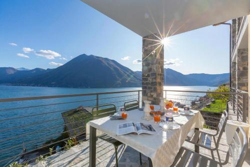 a table on a balcony with a view of the water at Residence degli Oleandri 2A in Argegno