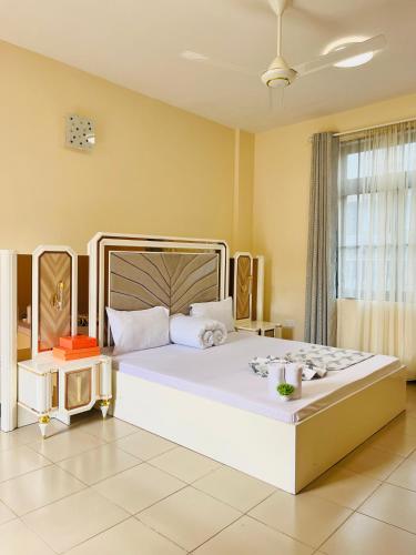 a bedroom with a large white bed in a room at QD Apartment Simba Unit in Arusha