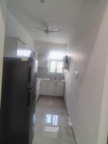 an empty kitchen with a refrigerator and a window at Ganga Bliss in Rishīkesh