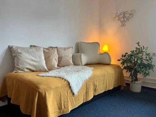 a bed with a yellow blanket and a plant at Ferienwohnung Lukas in Frielendorf