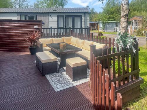 a patio with a couch and a table on a deck at Yolo Retreat in Felton