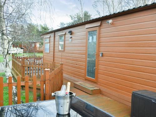 a cabin with a wooden deck with a door at Yolo Retreat in Felton