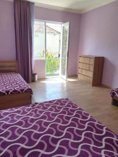 a bedroom with a bed and a room with a window at GuestHous LUKA in Manglisi