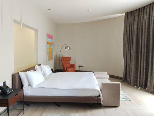 a bedroom with a large white bed and a desk at Gorgora Eco Resort in Gorgora