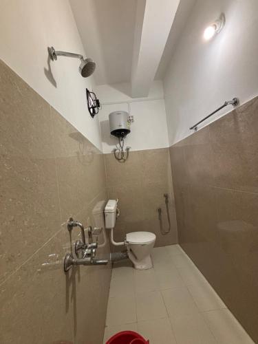a bathroom with a toilet and a shower at Mousumi Lodge in Tezpur