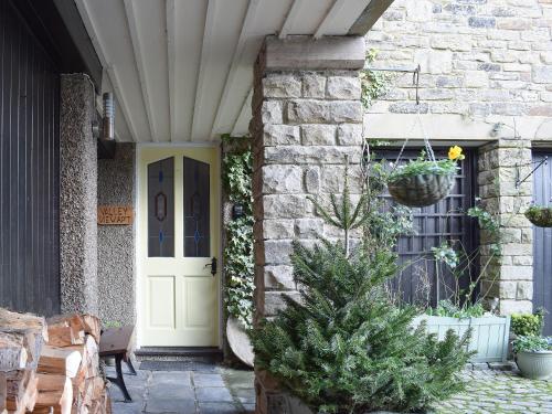 a house with a christmas tree in front of a door at Valley View in Burnsall
