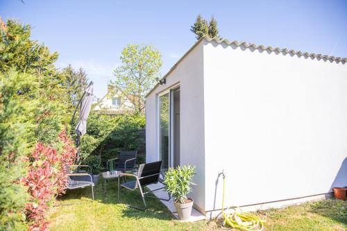 a garden room with a table and chairs on a patio at Rez de Jardin - Calme & Familiale in Varreddes