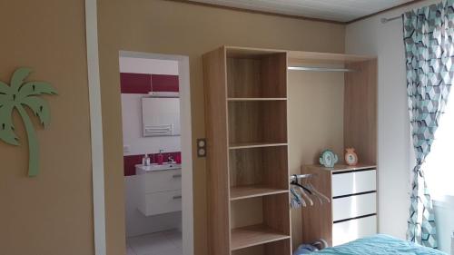 a bedroom with a book shelf and a bathroom at Maison une chambre avec jardin in Les Sables-d'Olonne