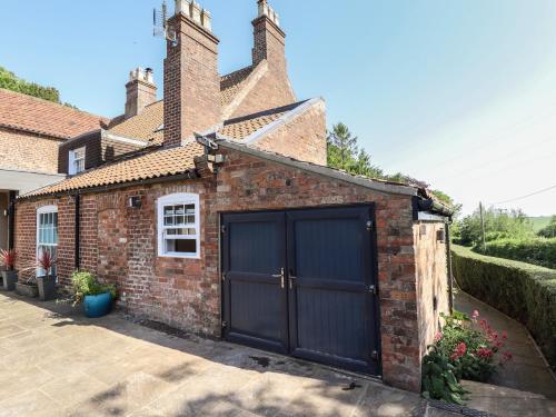 a brick garage with a blue garage door at Ivy House in Louth