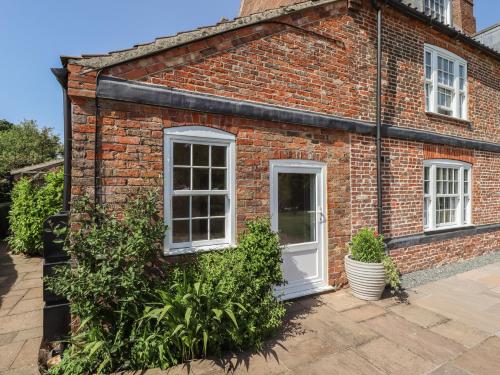 an old brick house with a white door at Ivy House in Louth