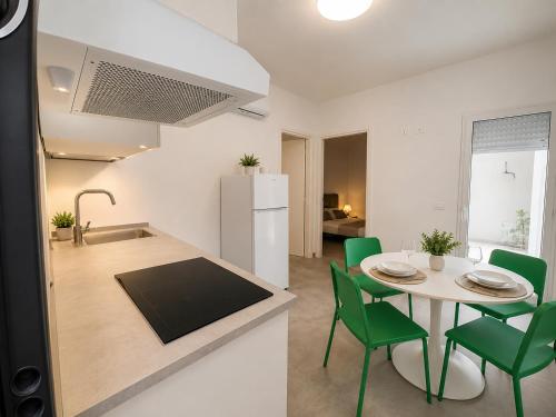a kitchen and dining room with a table and green chairs at Domus Palatium in Palazzolo Acreide