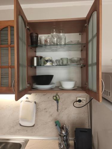 a kitchen with a cabinet with some dishes on it at Apartment in the Center 2 in Varna City