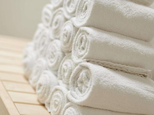 a stack of white towels sitting on a floor at ibis styles Dax Centre in Dax