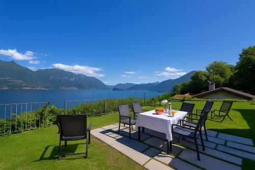 a table and chairs on a patio with a view of a lake at Casa Laura Apt 3 in Menaggio